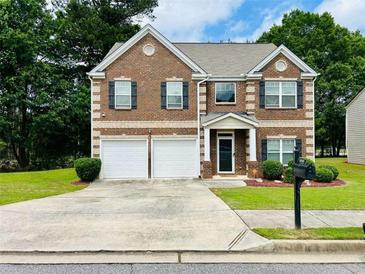 Charming brick two-story home with a well-manicured lawn and a two-car garage at 5848 Rex Ridge Loop, Rex, GA 30273