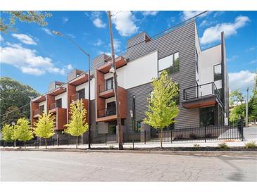 Modern townhome with gray siding, private balconies, a black fence, and young street trees at 367 Parkway Ne Dr # 6, Atlanta, GA 30312