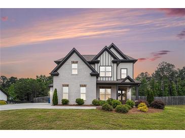 Beautiful two-story home with a brick facade, black trim, a well-manicured lawn, and professional landscaping at 1660 Chandler Rd, Lawrenceville, GA 30045