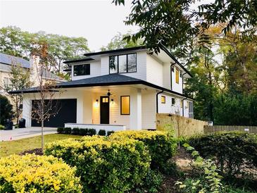 Beautifully landscaped home boasts a two-story facade, a black garage door, and a welcoming front porch at 206 Mead Rd, Decatur, GA 30030