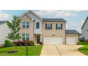 Charming two-story home with a brick facade, three-car garage, manicured lawn and inviting front door at 5025 Bryce Ln, Cumming, GA 30040