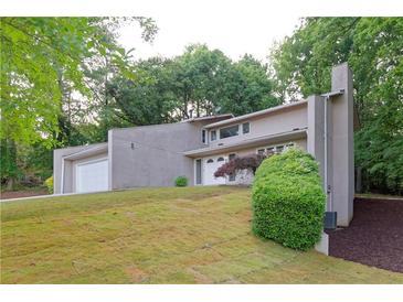 Stunning two-story home showcasing a well-manicured lawn and inviting curb appeal in a serene, wooded setting at 6010 Spalding Dr, Atlanta, GA 30350