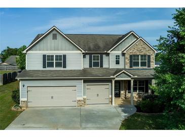 Charming two-story home with a two-car garage and beautifully manicured lawn at 9120 Alden Dr, Locust Grove, GA 30248