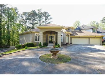 Stunning home features a circular driveway and beautifully landscaped front yard with an elegant fountain at 1010 Forest Overlook Sw Dr, Atlanta, GA 30331