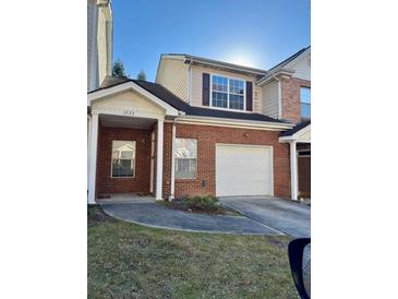 Charming brick townhome featuring an attached garage and inviting covered entryway at 2572 Laurel Cir, Atlanta, GA 30311