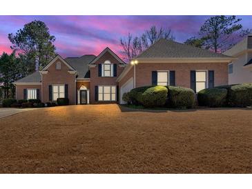 Charming brick home featuring manicured landscaping and a well-maintained front lawn at 2021 Cockrell Pointe Nw, Kennesaw, GA 30152