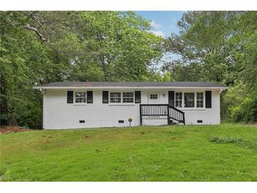 Charming one-story home with black shutters, landscaped yard and inviting entry at 2765 Ocean Valley Dr, Atlanta, GA 30349