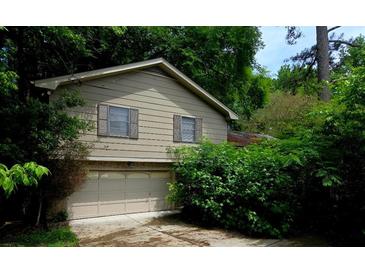 Two story home featuring a 2-car garage and neutral siding surrounded by lush greenery at 3530 Terri Lynn Ct, Tucker, GA 30084