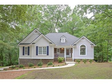 Charming home featuring blue shutters, a manicured lawn, and a welcoming front porch at 7533 Mason Falls Dr, Winston, GA 30187
