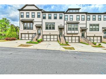 A stunning exterior view of modern townhomes, each featuring a private garage and inviting entryways at 1122 Provence Ln, Decatur, GA 30033