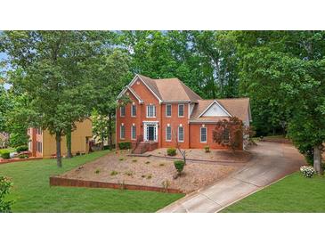 Stately two-story brick home with a well-manicured front yard and mature trees at 1952 Skidmore Cir, Lawrenceville, GA 30044