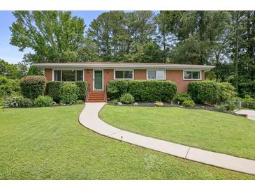 Charming brick home with a well-manicured lawn, beautiful shrubs, and a welcoming walkway to the front door at 388 Talcott Nw Cir, Marietta, GA 30064