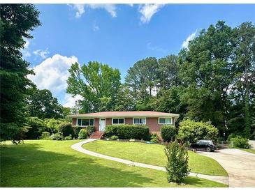 Charming one-story brick home with a well-manicured front lawn, a curved walkway, and mature landscaping at 388 Talcott Nw Cir, Marietta, GA 30064