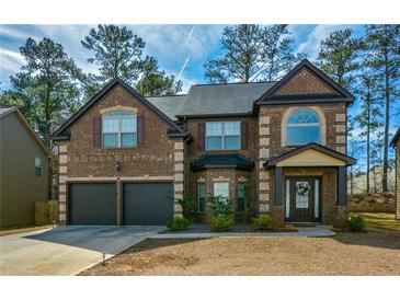 Charming two-story brick home featuring an attached two-car garage and covered front entrance at 9941 Musket Ridge Cir, Jonesboro, GA 30238
