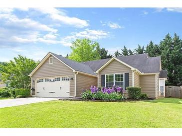 Charming single-story home with a well-manicured lawn and a lovely flower bed in the front yard at 1615 Nw Vinebrook Nw Ter, Kennesaw, GA 30144