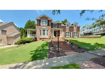 Beautiful two-story brick home with meticulously maintained front yard and grand entrance with brick steps at 4541 Meadow Club Dr, Suwanee, GA 30024