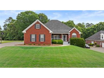 Charming brick home boasts a well-manicured lawn and inviting front porch at 9507 Greens Mill Ct, Loganville, GA 30052