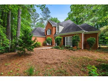 Charming brick home with mature landscaping and dark shutters on a lush, wooded lot at 1772 Benningfield Sw Dr, Marietta, GA 30064