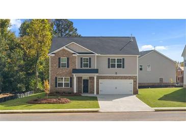 Charming two-story home with brick and siding exterior, well-manicured lawn, and attached two car garage at 1940 Van Allen Ct, Dacula, GA 30019