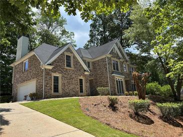 Charming brick home with a well-manicured lawn and mature trees offering shade and curb appeal at 753 Hayes Ct, Atlanta, GA 30349