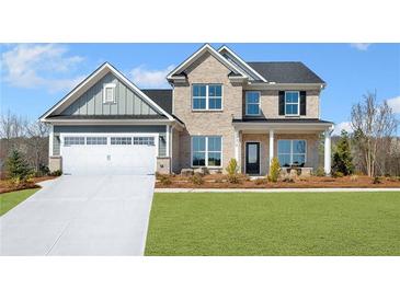 Inviting two-story home features a brick and siding exterior with a two-car garage and a well-manicured front lawn at 5350 Hyde Rd, Cumming, GA 30040