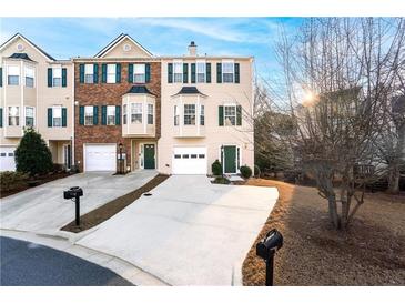 Charming townhome featuring a one car garage, green shutters, and bay windows, creating a welcoming curb appeal at 805 Abbotts Mill Ct # 74, Duluth, GA 30097