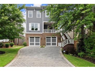 Charming two-story home featuring gray siding, brick accents, and a spacious two-car garage at 1104 Victoria Ne St, Brookhaven, GA 30319