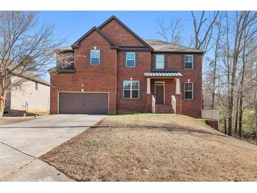 Charming two-story brick home features a two-car garage and a well-manicured lawn at 3313 Alhambra Cir, Hampton, GA 30228