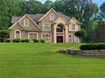 Stunning two-story brick home with arched windows and a meticulously manicured lawn at 45 Mountain Crest Dr, Oxford, GA 30054