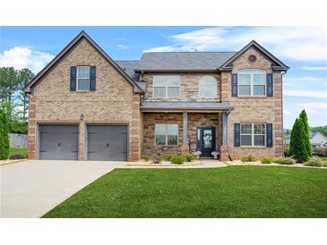 Beautiful two-story brick home with a manicured lawn and a two-car garage at 321 Shannon Ct, Mcdonough, GA 30252