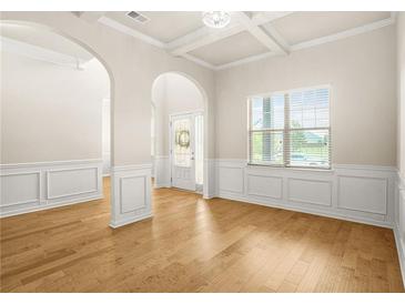 Bright living room featuring hardwood floors, wainscoting and an arched entryway at 321 Shannon Ct, Mcdonough, GA 30252