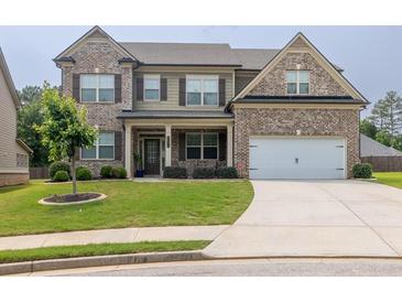 Charming two-story home with a well-manicured lawn and brick and siding exterior at 3302 Avenel Ct, Snellville, GA 30078