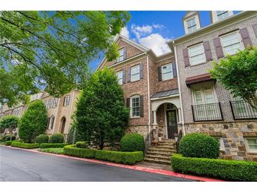Charming brick townhome with manicured landscaping, stone accents, and inviting curb appeal at 2313 Saint Davids Nw Sq # 12, Kennesaw, GA 30152
