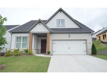 Charming single Gathering home featuring brick accents, a two-car garage and a well manicured lawn at 423 Ward Ln, Woodstock, GA 30188