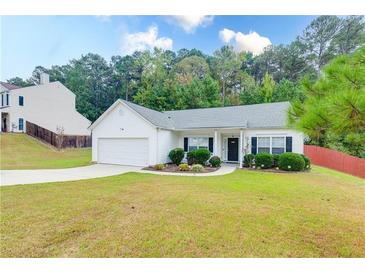 Charming single-story home with a well-manicured lawn, attached garage, and inviting front entrance at 2221 Baker Carter Dr, Loganville, GA 30052