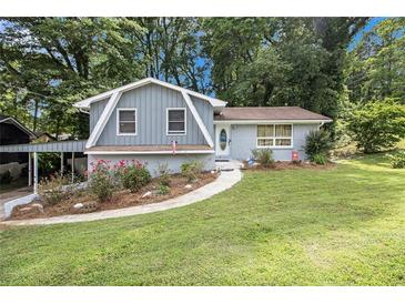 Charming two-story home with a well-maintained lawn, flowering bushes, and beautiful landscaping at 2950 Springfield Sw Ct, College Park, GA 30349