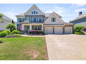 Charming two-story home featuring a three-car garage, manicured lawn and lush landscaping at 337 Spotted Ridge Cir, Woodstock, GA 30188