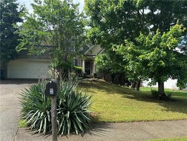 Traditional home featuring a manicured lawn and mature trees providing shade and curb appeal at 34 Hunters Xing, Dallas, GA 30157