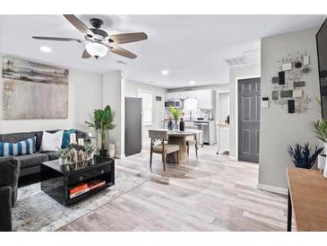 Open-concept living room featuring modern decor, updated flooring, and stainless steel appliances at 246 Aurora Nw Ave, Atlanta, GA 30314