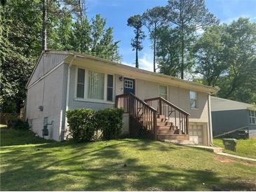 Charming grey-painted brick home with a front yard and wood porch steps at 115 Delmoor Nw Dr, Atlanta, GA 30311