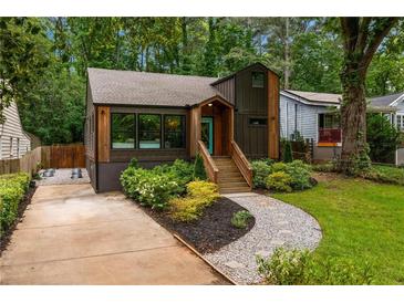 Charming home featuring a brown facade, inviting front porch, landscaped yard, and convenient driveway at 2001 Swazey Dr, Decatur, GA 30032