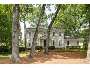 Charming two-story traditional home with a manicured lawn and mature trees providing shade at 1404 Vernon North Dr, Dunwoody, GA 30338