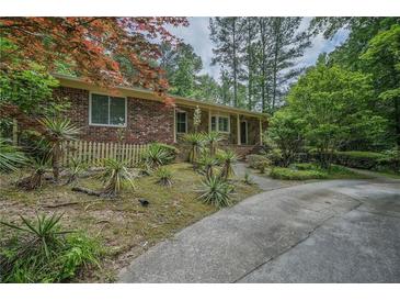 Charming brick home with a long driveway and unique landscaping creating great curb appeal at 648 Cativo Sw Dr, Atlanta, GA 30311