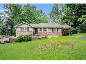 Charming single-story home featuring a brick facade, manicured lawn, and a convenient carport at 2714 Laurel Ridge Dr, Decatur, GA 30033