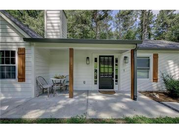 Charming front porch with seating area, rustic wood columns, and a modern front door with sidelights at 232 Apple Branch Dr, Woodstock, GA 30188