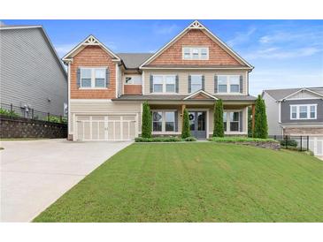 Charming two-story home featuring a manicured lawn, a two-car garage and inviting front porch at 411 Ridgeway Ln, Canton, GA 30114