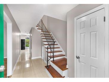 Inviting entryway showcasing wood stairs with metal railing and beige tile flooring at 2340 Beaver Ruin Rd # 68, Norcross, GA 30071