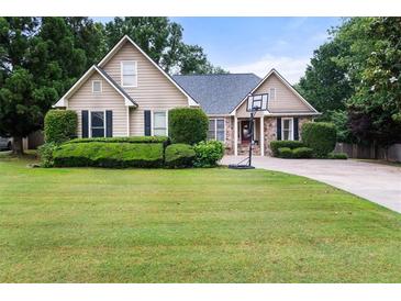Charming single-Gathering home with manicured lawn and basketball hoop on driveway at 2835 Channing Way, Cumming, GA 30040
