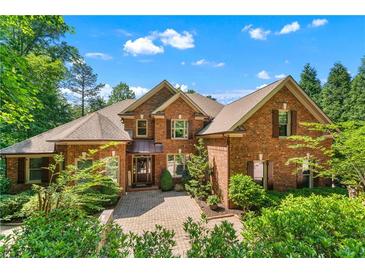 Beautiful brick home with a well-manicured lawn and mature landscaping, creating inviting curb appeal at 5765 Riley Rd, Cumming, GA 30028