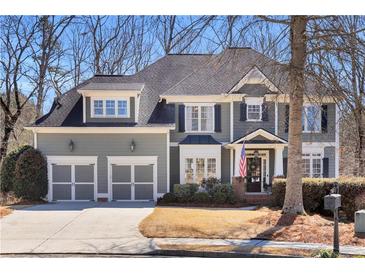 Charming two-story home with a manicured lawn, two-car garage and an American flag at 1604 Summersweet Ln, Dacula, GA 30019